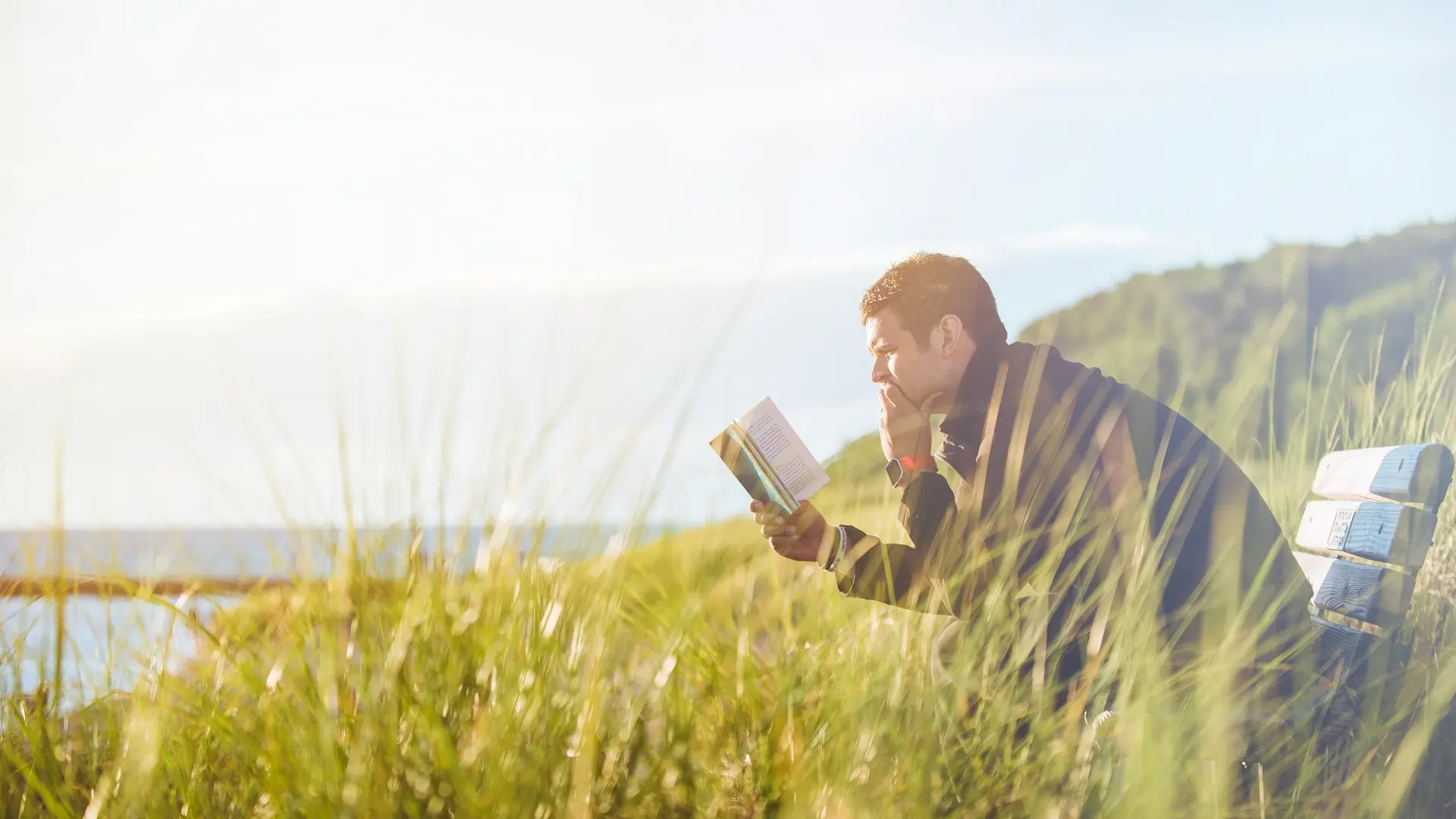 sitting on bench reading book